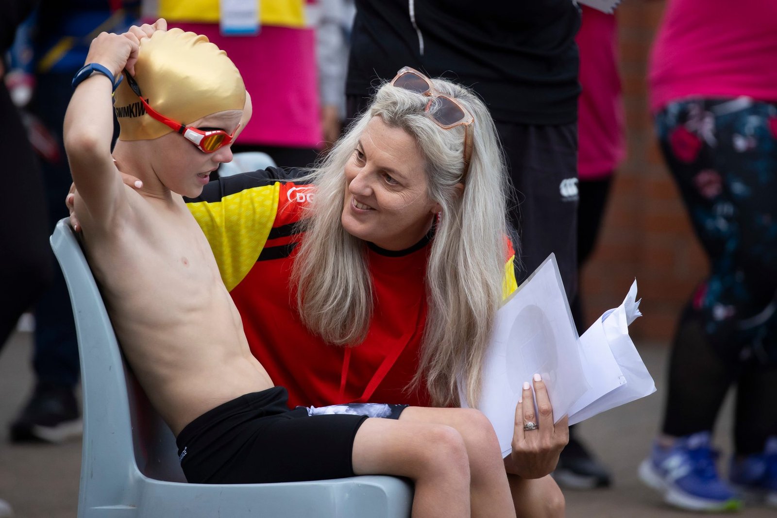 Zac Schultz in his swim cap and goggles being helped to warm up before racing at the 2021 Halberg Games